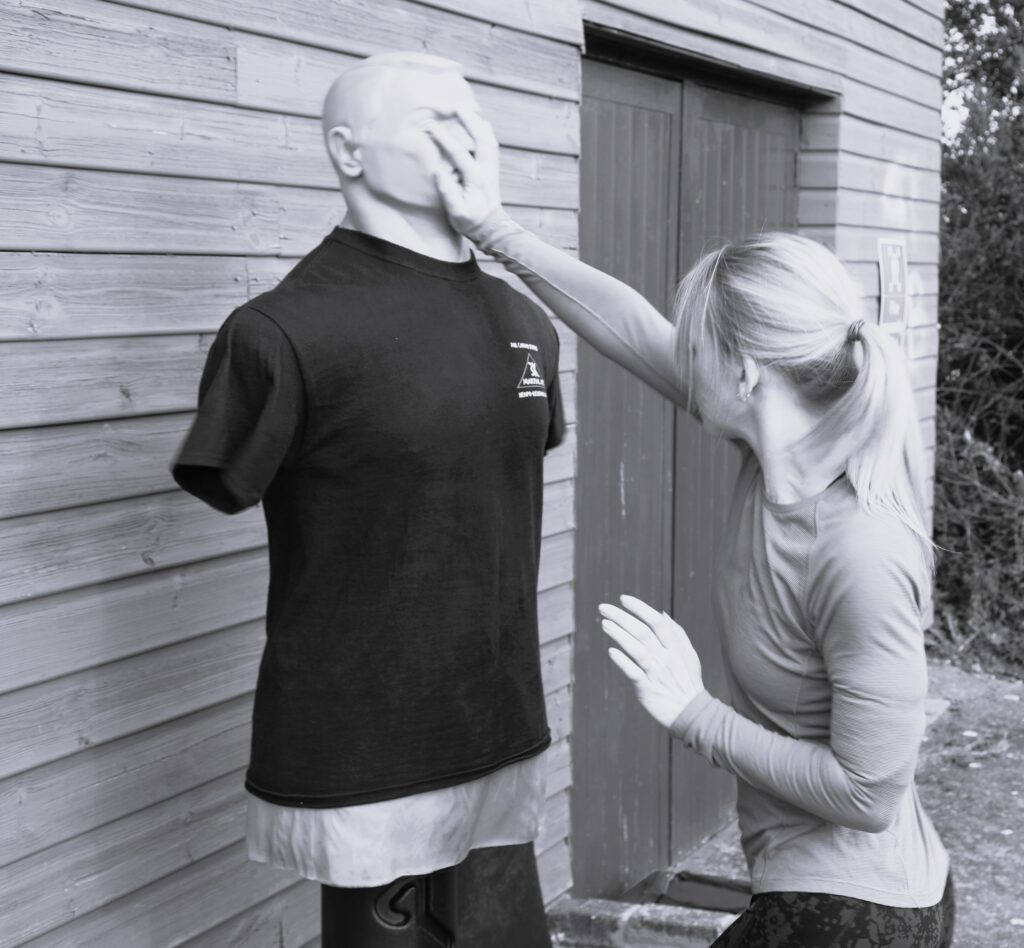 Woman doing self defence against dummy